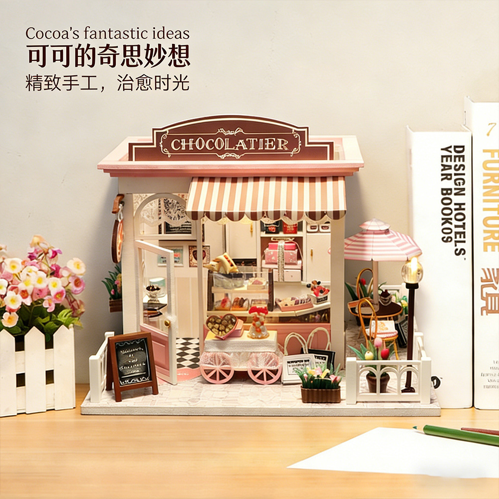 Hongda DIY miniature chocolate house model displayed as cozy desk decor with pastel storefront, dessert cart, and charming handmade café-style details