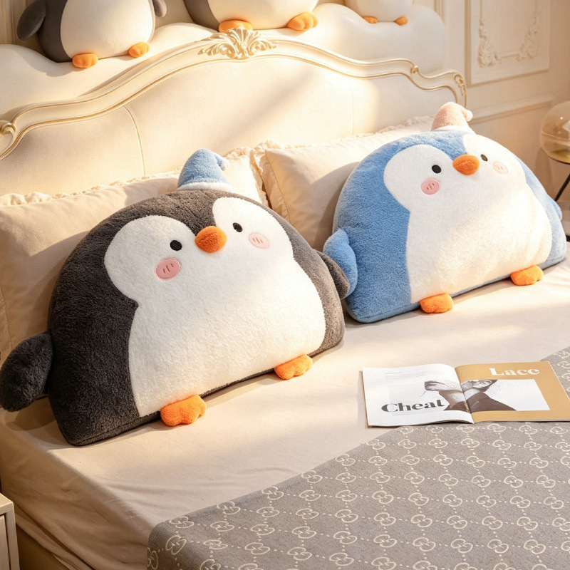 Gray and blue penguin plush backrest pillows styled on a bed with soft plush texture and cozy bedroom atmosphere