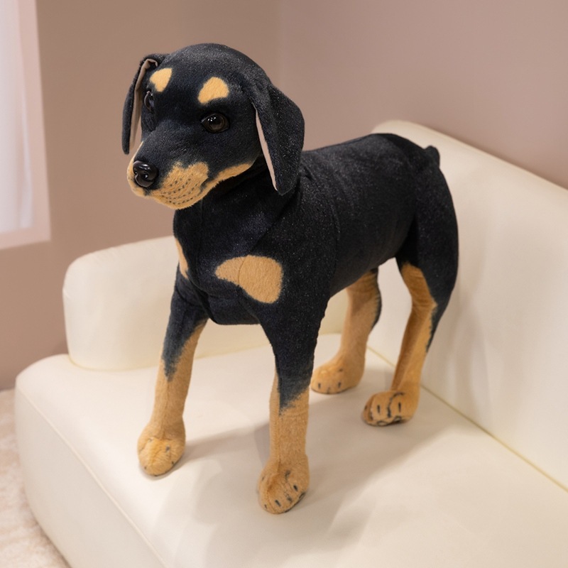 Realistic Rottweiler plush toy displayed on a sofa as a decorative companion piece