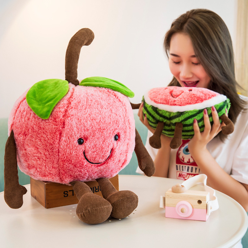 Cute watermelon and cherry plush toys with embroidered smiling faces, soft plush texture, and playful dangling limbs, creating a cheerful and cozy display