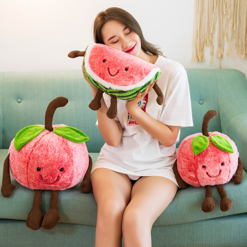 Smiling watermelon plush toy with soft cuddly texture, striped rind details, and dangling limbs, creating a cozy and comforting accent for sofas, beds, and living spaces