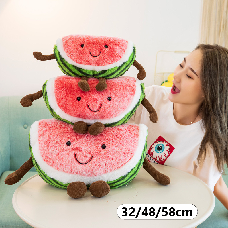 Stacked smiling watermelon plush toys in multiple sizes, featuring soft plush fabric, embroidered faces, and playful dangling arms and legs for cozy decor and cuddling