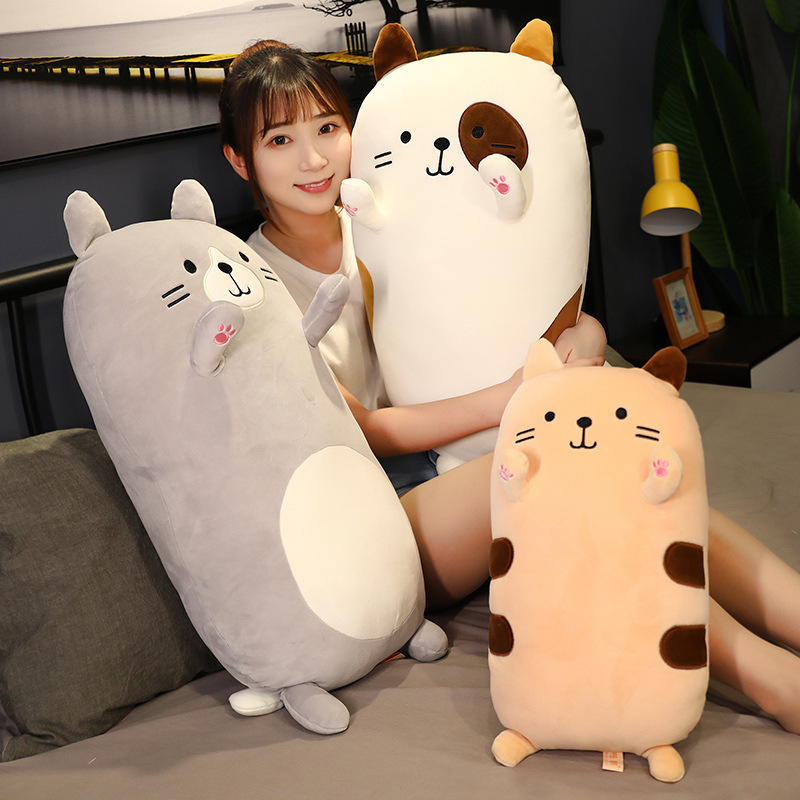 Cat Plush Pillow in multiple sizes and colors displayed on a bed, featuring embroidered whiskers, raised paws, and a soft plush finish