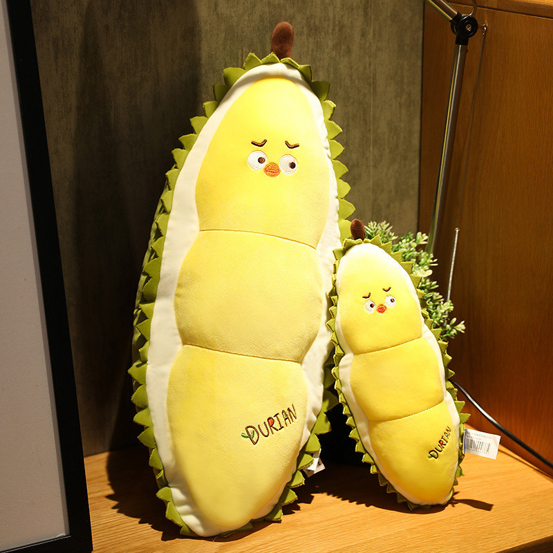 Durian Chick Plush Pillows displayed on a wooden shelf, showcasing available sizes and soft plush texture for home decor