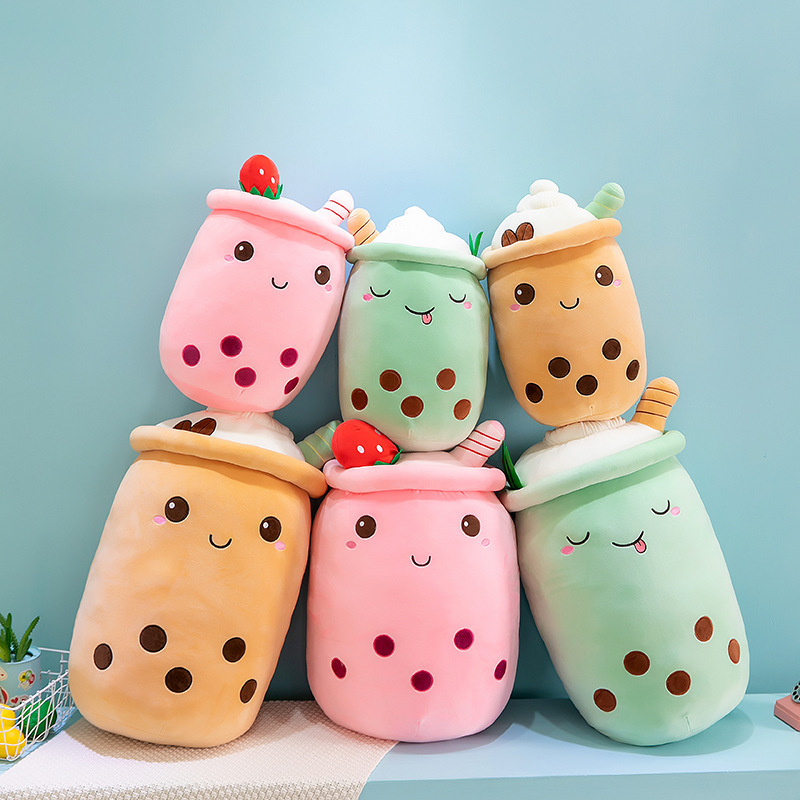 Assorted ice cream bubble tea plush pillows arranged in a playful stacked display, highlighting multiple colors, sizes, and embroidered details