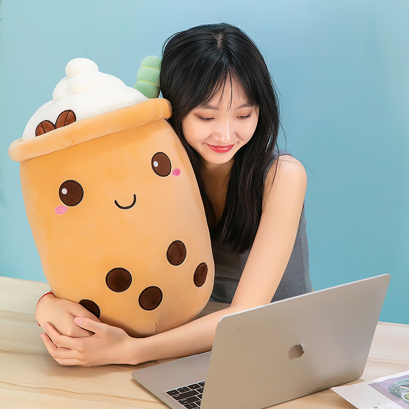 Ice cream bubble tea plush pillow with embroidered boba pearls and whipped cream details, providing soft comfort beside a desk or reading space