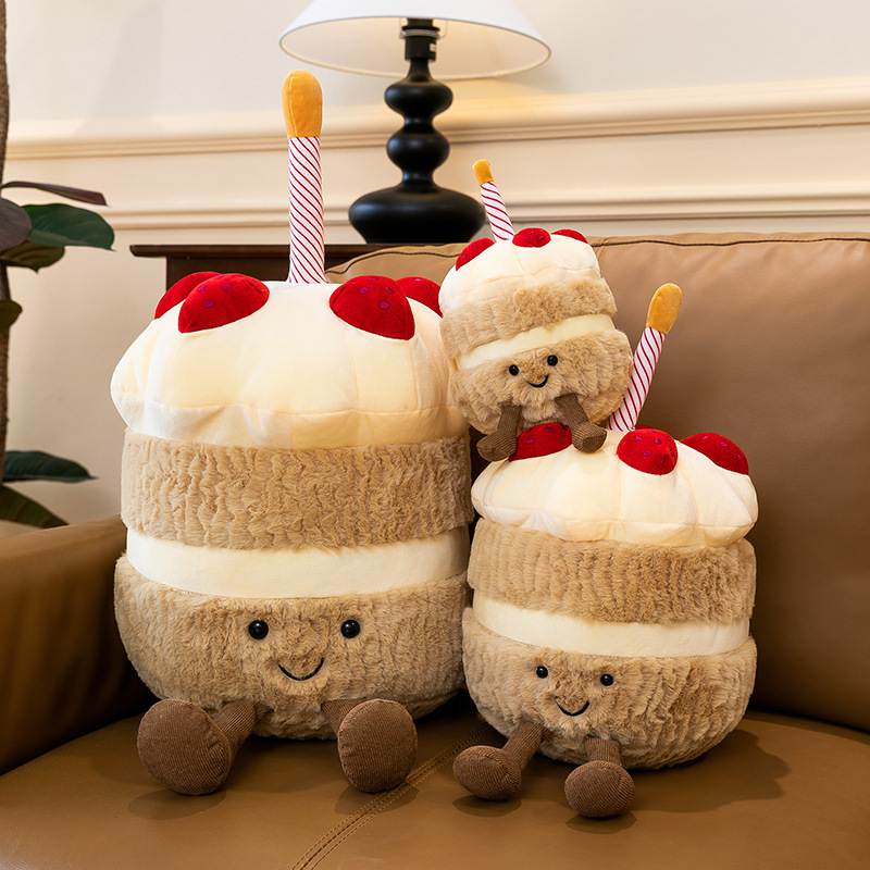 Birthday Cake Plush Toys in multiple sizes displayed on a sofa, showcasing soft plush fabric, cake-inspired layers, dangling legs, and cozy home decor appeal