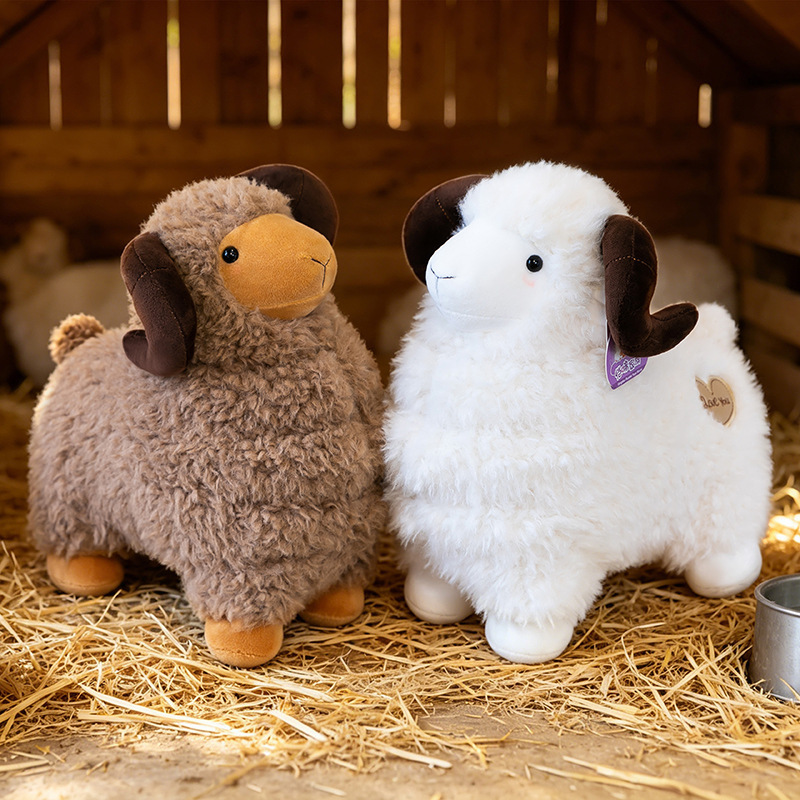 Brown and white Bighorn Sheep Plush Toys with fluffy wool-like texture and curved horns displayed in a cozy barn setting