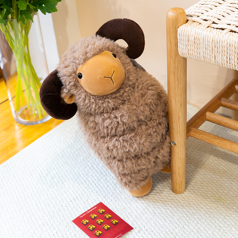 Brown Bighorn Sheep Plush Toy with fluffy wool-like texture and curved horns beside a woven chair