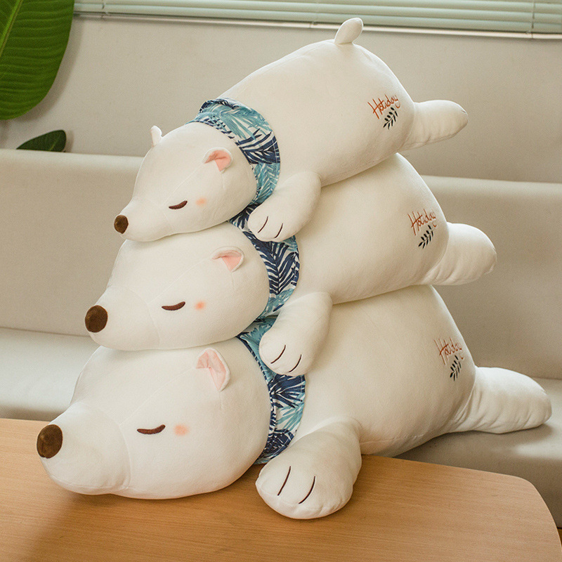 Polar Bear Plush Pillows stacked together on a sofa, highlighting the sleeping bear design and available size options