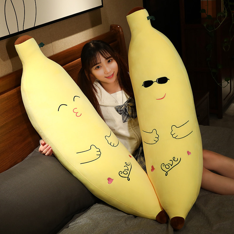Cute Banana Plush Pillows in Kissing and Sunglasses styles displayed on a bed, showcasing playful expressions and long plush body pillow shapes