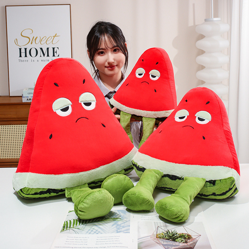 Funny Watermelon Plush Pillow in multiple sizes with a playful sleepy-eyed expression and dangling legs, displayed as cheerful fruit-themed decor for cozy living spaces