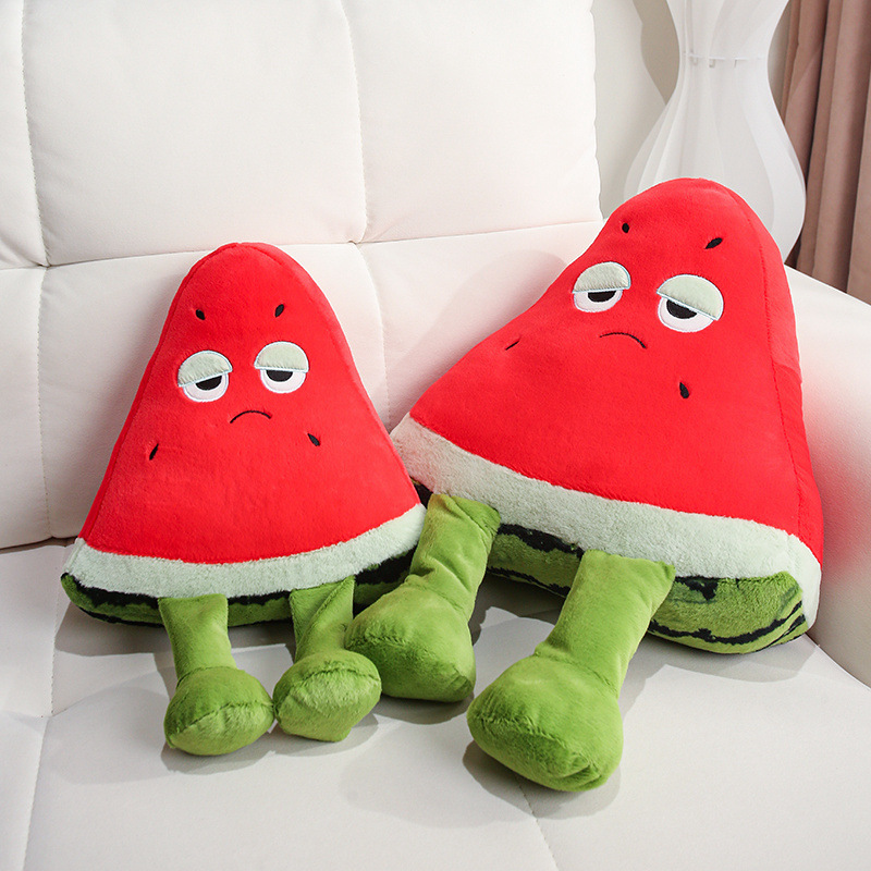 Funny Watermelon Plush Pillow pair with sleepy-eyed expressions and dangling legs, displayed on a sofa as playful fruit-themed home decor