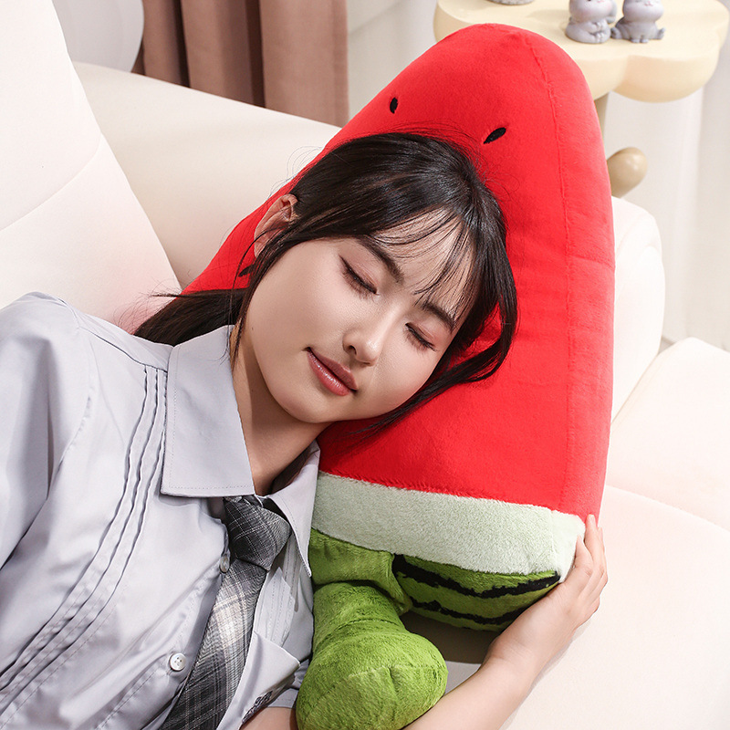 Funny Watermelon Plush Pillow used as a soft cushion for resting, featuring a humorous sleepy-eyed expression and dangling legs
