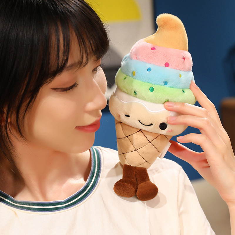 Rainbow Ice Cream Plush Toy with embroidered winking face, waffle cone base, and dangling legs, highlighting its soft texture and cheerful design