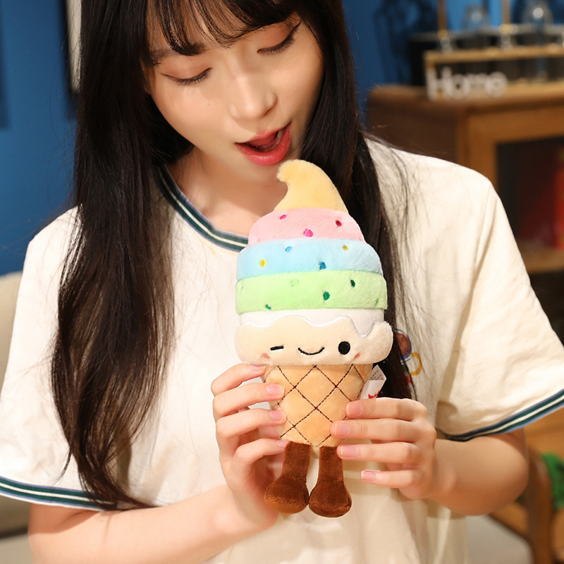 Rainbow Ice Cream Plush Toy featuring colorful soft serve layers, embroidered winking face, and dangling legs, showcasing its compact and huggable size