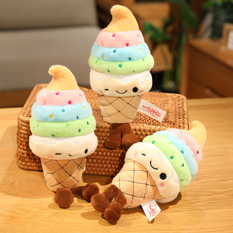 Rainbow Ice Cream Plush Toys featuring colorful soft serve layers, embroidered winking faces, and dangling legs displayed on a tabletop