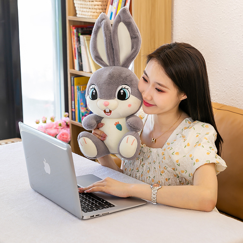 Gray Sweet Bunny plush toy displayed beside a laptop, creating a cozy workspace companion and cheerful desk decor accent