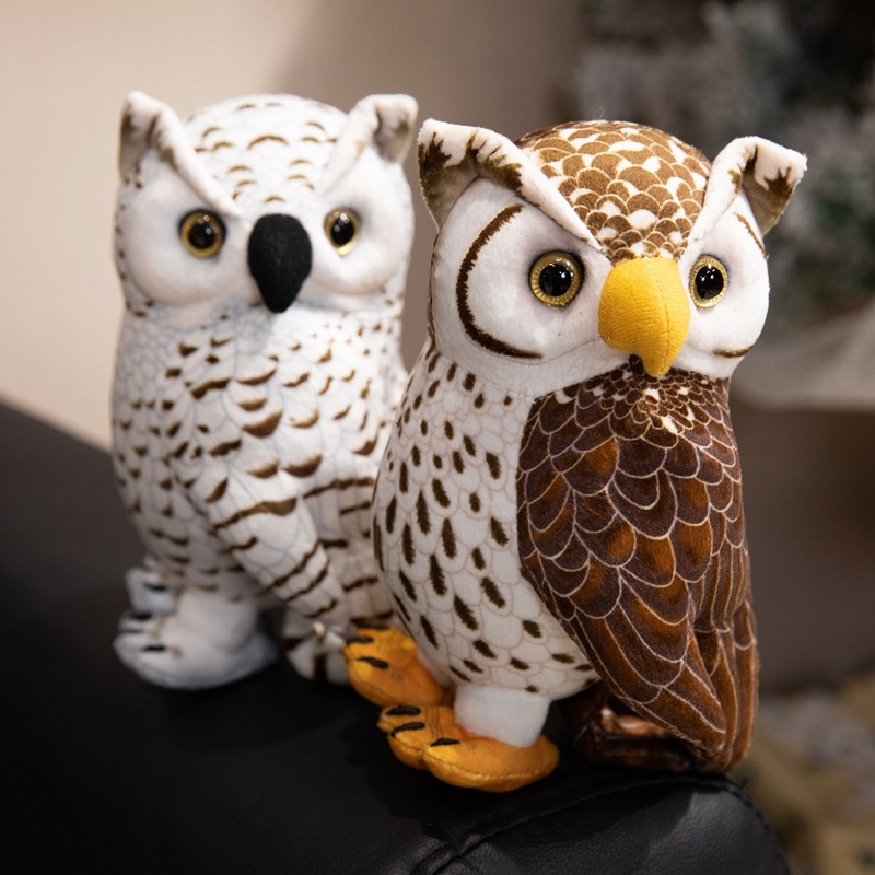 Brown and white owl plush toys displayed together on a chair, featuring realistic feather patterns, expressive eyes, and a charming woodland-inspired design