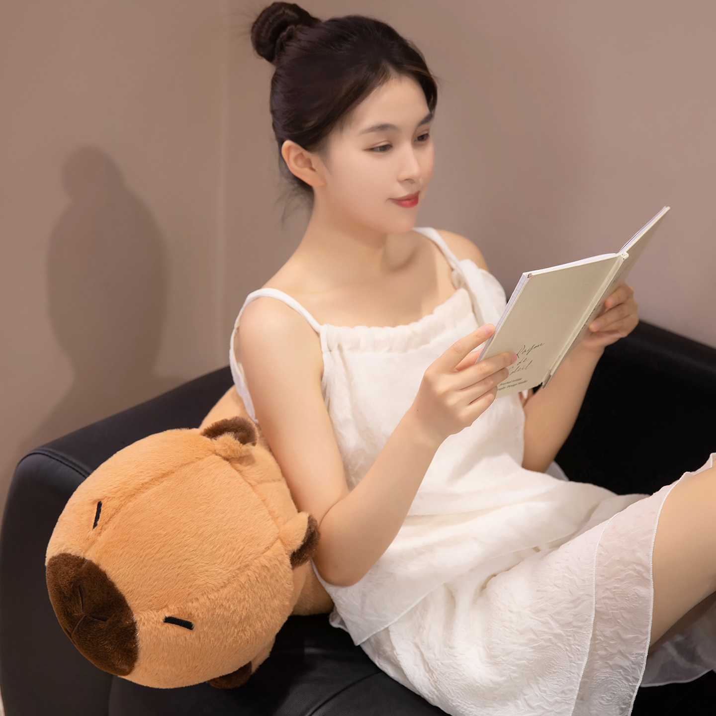 Lucky Capybara plush body pillow used as a soft back cushion while reading, adding comfort and cozy charm to a living room or bedroom