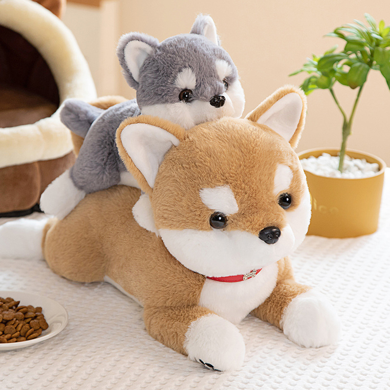 Brown and gray Shiba Inu plush toys stacked together on a bed for a playful and cozy display