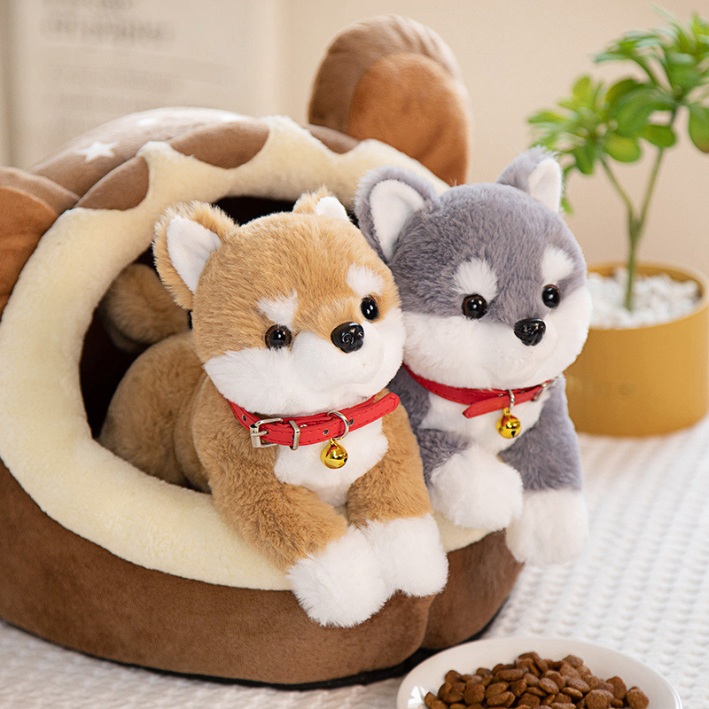 Brown and gray Shiba Inu plush toys resting in a cozy pet bed, creating a warm and playful display