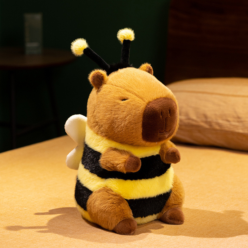 Bee Capybara Plush Toy sitting on a tabletop with soft bee-striped body, plush wings, fuzzy antennae, and a cheerful design for display and cuddling