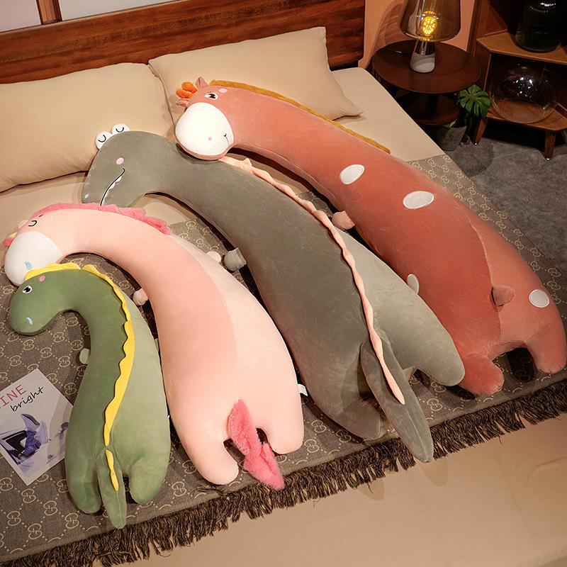 Giraffe, unicorn, and dinosaur long plush pillows arranged on a bed, highlighting the different animal designs and soft plush construction for comfort and decor