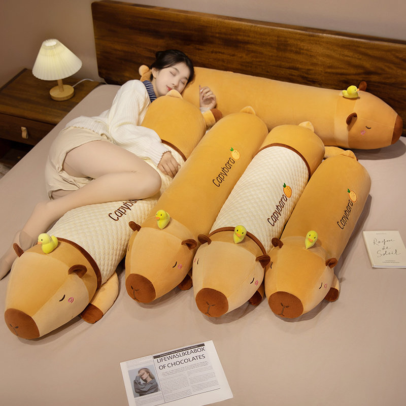 Cute Capybara Long Plush Pillows in plush and cooling fabric styles displayed on a bed, featuring a sleepy capybara design and tiny duck companions