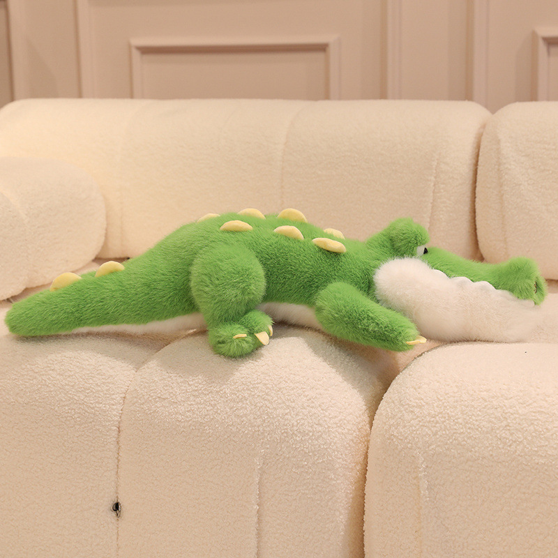 Cute Crocodile Plush Toy displayed on a sofa, highlighting its long body shape, padded spikes, and soft plush texture