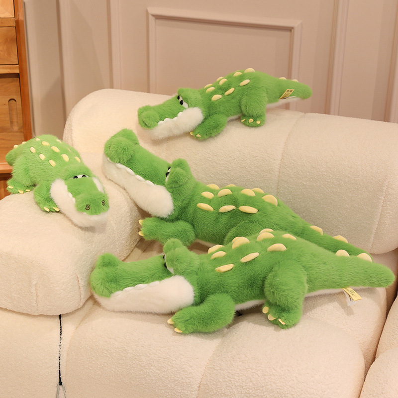 Cute Crocodile Plush Toy displayed in multiple sizes on a cozy sofa, featuring soft plush fabric, embroidered details, and a playful crocodile design