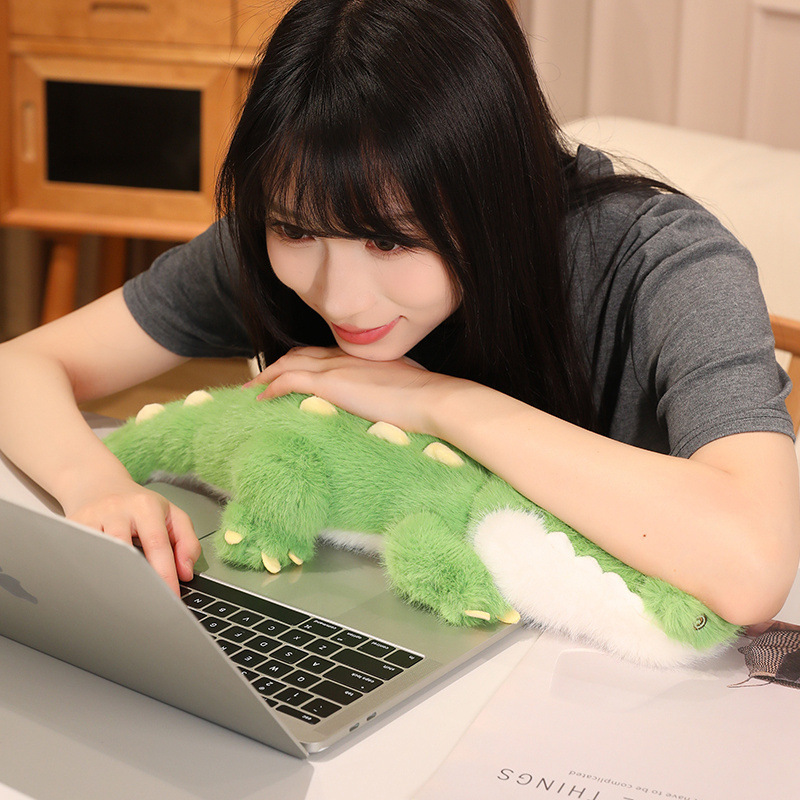 Cute Crocodile Plush Toy resting beside a laptop, adding comfort and playful charm to a workspace