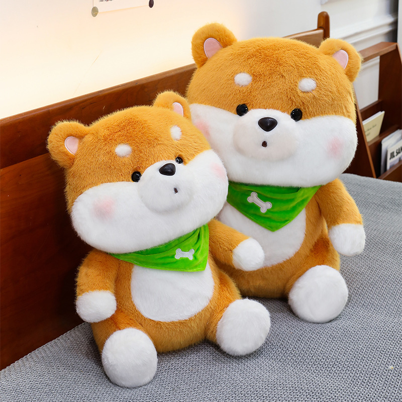 Two Shiba Inu plush toys with green bandanas displayed on a bed in a cozy home setting