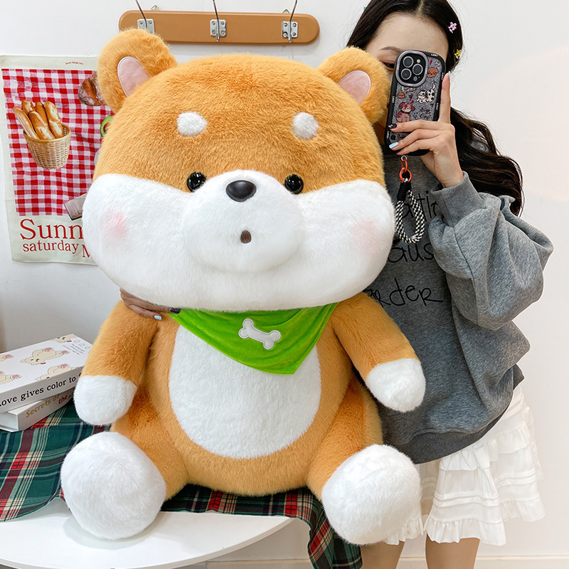 Shiba Inu plush toy with a green bandana displayed in a cozy indoor setting, showcasing its round face and fluffy cheeks