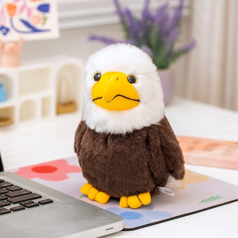 Bald Eagle Plush Toy standing on a desk mat, featuring fluffy white head feathers, brown body, and realistic eagle-inspired details