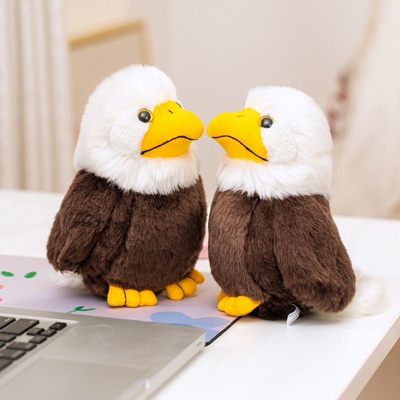 Two Bald Eagle Plush Toys displayed beside a laptop, featuring fluffy white feathers, yellow beaks, and a charming wildlife-inspired design for desks and shelves