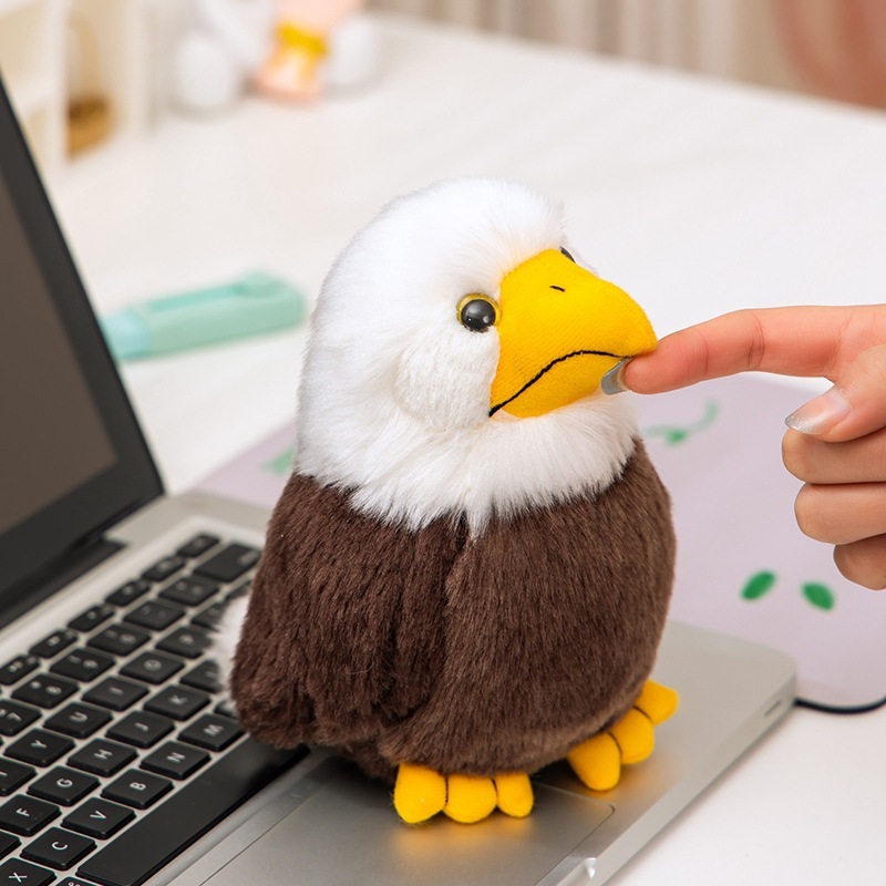 Bald Eagle Plush Toy with detailed yellow beak and soft feather-like plush texture, displayed beside a laptop on a desk