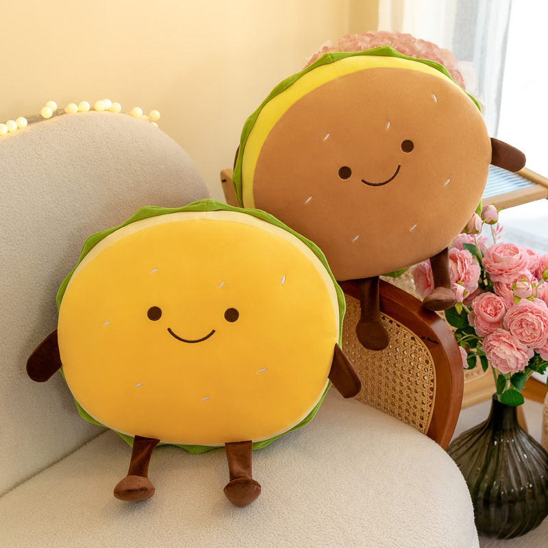 Yellow and brown burger plush pillows displayed on a cozy chair, showcasing adorable smiling faces, soft plush texture, and playful food-inspired home decor