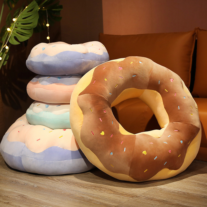 Chocolate Donut Plush Pillow displayed with raspberry, taro, and sea salt donut plush pillows in a cozy home setting