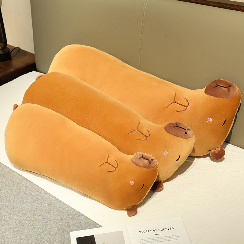 Three Capybara Long Plush Pillows arranged on a bed, showcasing their soft plush fabric, rounded body shape, and cozy design for hugging, lounging, and sleeping