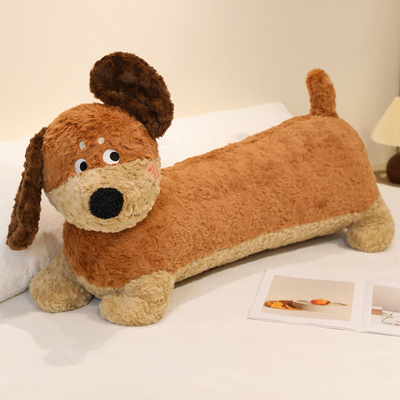 Dachshund Plush Pillow displayed on a bed, featuring a long dog design, soft plush fabric, and a cozy shape for hugging, relaxing, or decorating bedrooms