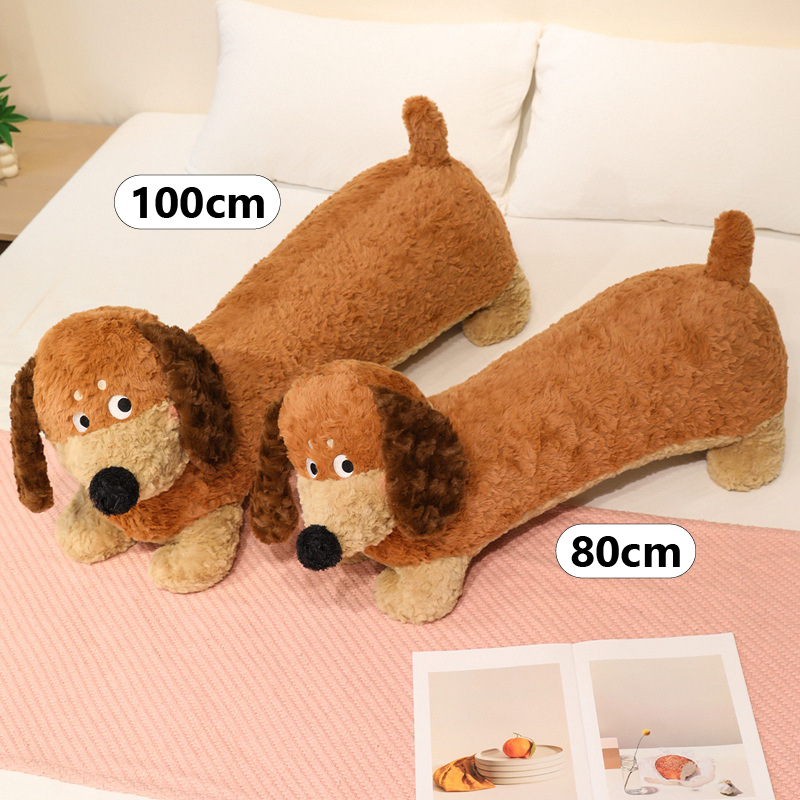 Dachshund Plush Pillow size comparison showing 80 cm and 100 cm options on a bed
