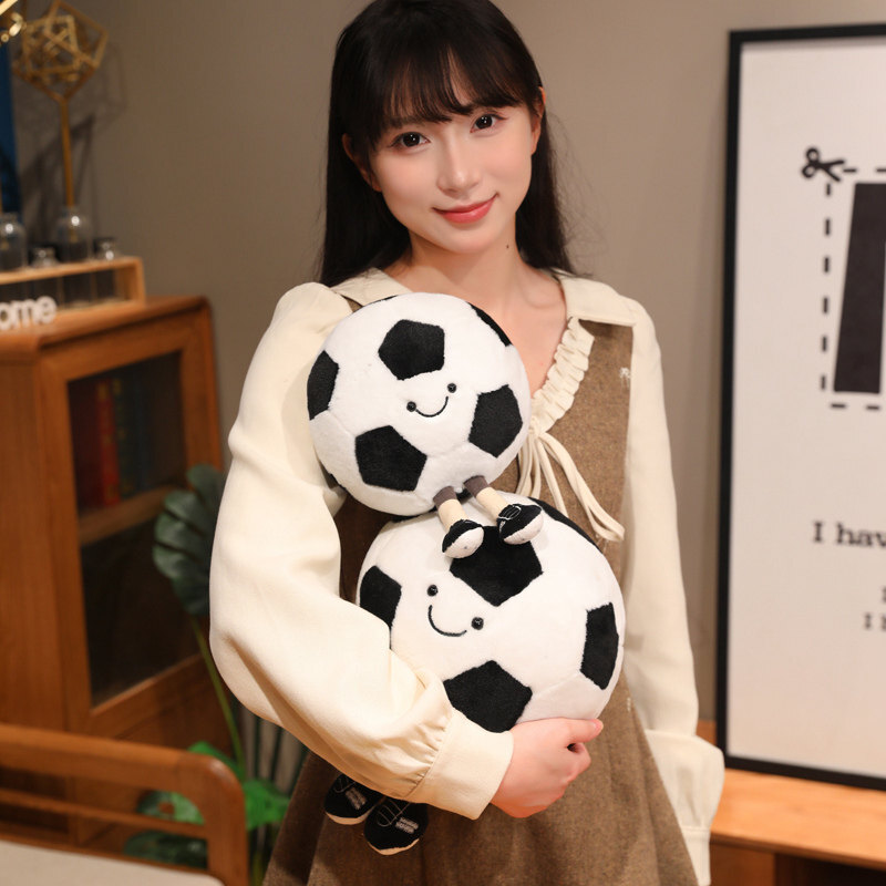 Soccer Ball Plush Toys in two sizes with smiling faces and dangling legs, highlighting their cuddly design