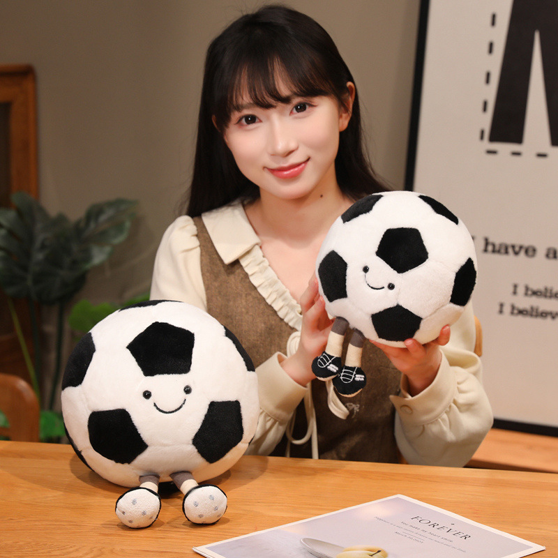 Soccer Ball Plush Toys in different sizes featuring smiling faces, dangling legs, and soft plush fabric for display or cuddling