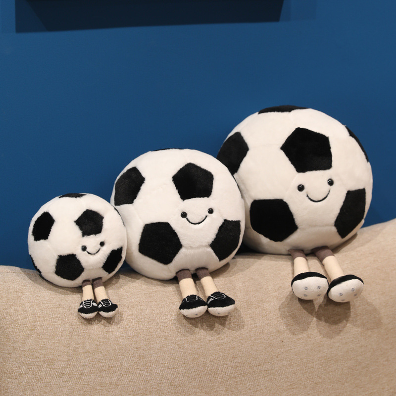 Soccer Ball Plush Toys in multiple sizes with smiling faces and dangling legs, perfect for shelves and cozy decor