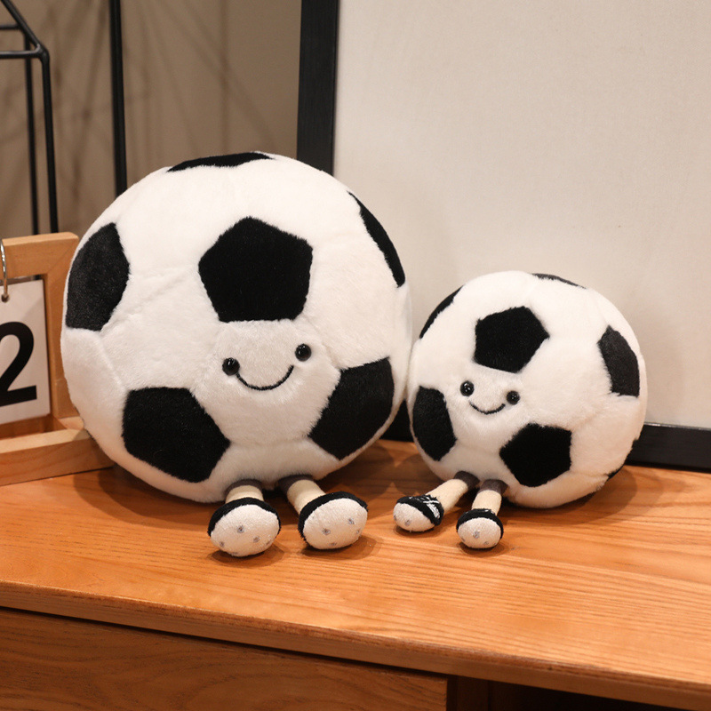 Soccer Ball Plush Toys in two sizes with cheerful smiles and dangling legs, perfect for desks, shelves, and home decor