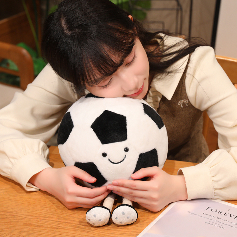 Soft Soccer Ball Plush Toy with a cheerful smiling face and dangling legs, perfect for cuddling and relaxing