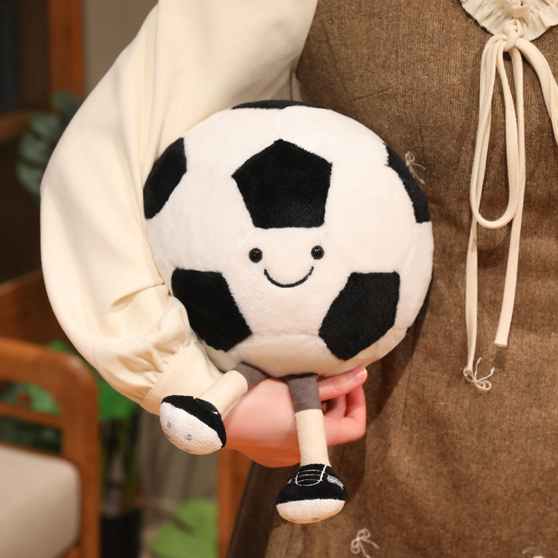 Soccer Ball Plush Toy with a smiling face and dangling legs, showing its soft, cuddly size for hugging