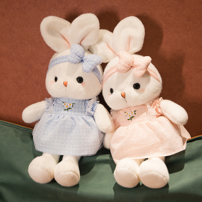 Cute Bunny Plush Toys in blue and pink featuring soft plush fabric, embroidered daisy dresses, and matching bow headbands in a cozy display