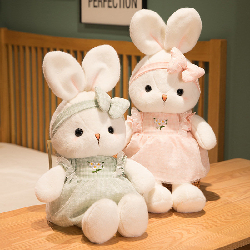 Cute Bunny Plush Toys in pink and green featuring embroidered daisy dresses, matching bow headbands, and soft plush fabric in a cozy tabletop display